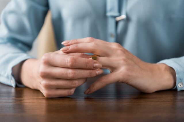 person taking off their wedding ring