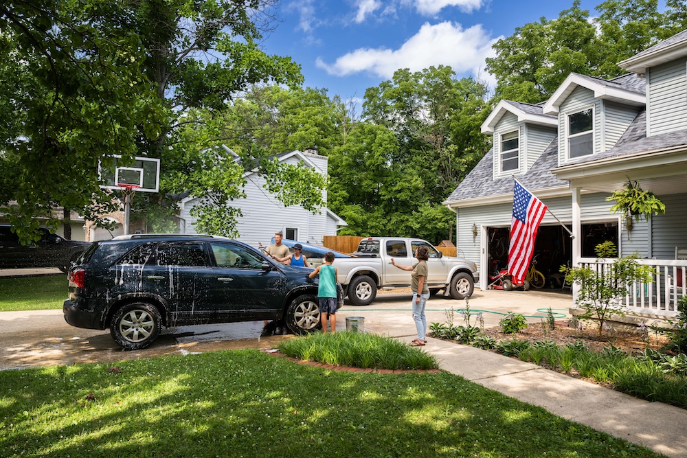 Air Force service member washes his vehicles with his sons in the driveway 3