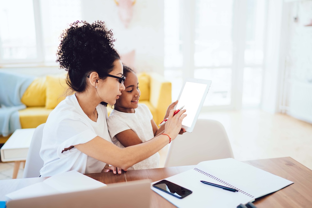 Ethnic parent and child browsing social media using tablet