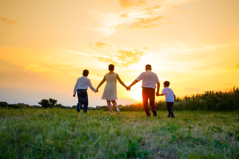 Happy family on the background of the sunset
