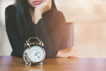 woman with alarm clock waiting